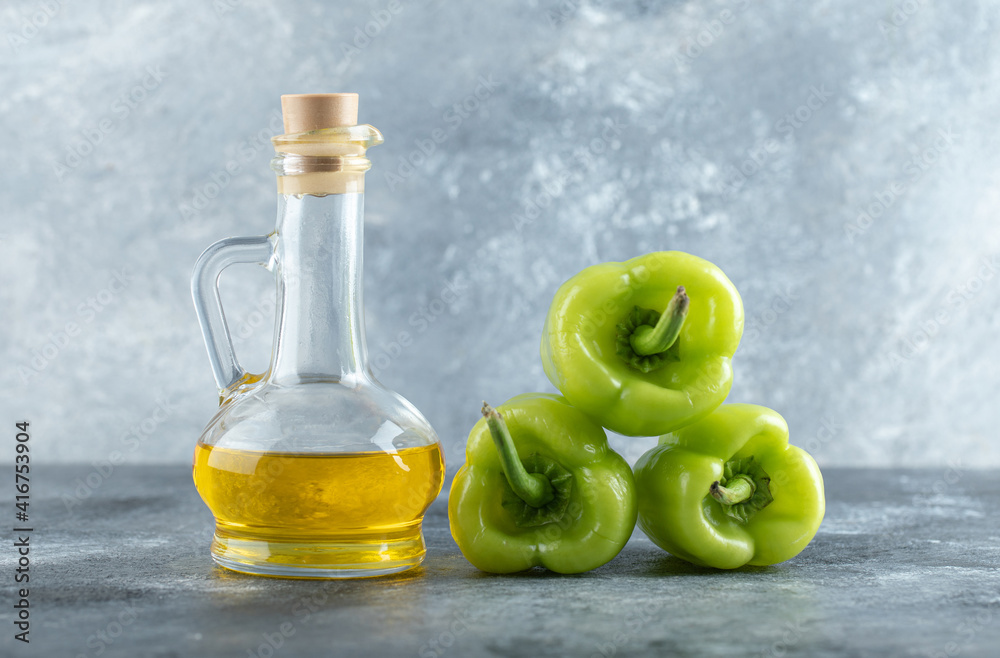 Stack of sweet peppers with bottle of oil Stack of sweet peppers with bottle of oil