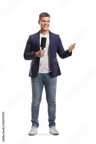 Foto Full length portrait of male reporter holding a microphone and gesturing with ha