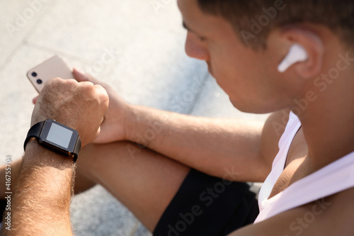 Man checking fitness tracker after training outdoors  closeup