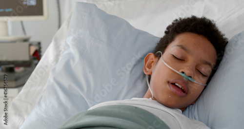 Quadro em tela Close up of ill african kid having fever sleeping in bed at hospital