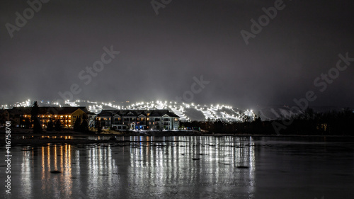 View of Blue Mountain ski resort and village from Lighthouse Point, Collingwood, Ontario. Ski runs are lit up for night skiing for skiers and snowboarders to ski at night during the winter photo