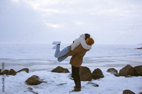 A romantic photo session of a girl and a guy in the Gulf of Finland in winter. Love story and happiness.