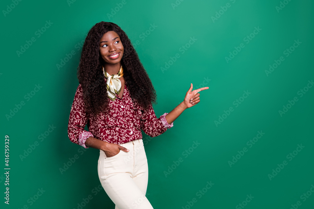 Photo of cute shiny curly dark skin woman dressed red shirt looking pointing empty space isolated green color background Photo of cute shiny curly dark skin woman dressed red shirt looking pointing empty space isolated green color background