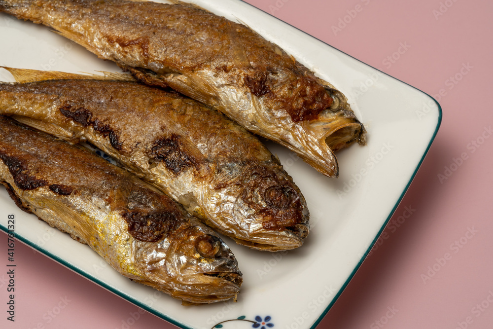 Close-up of croaker roast on pink background Close-up of croaker roast on pink background