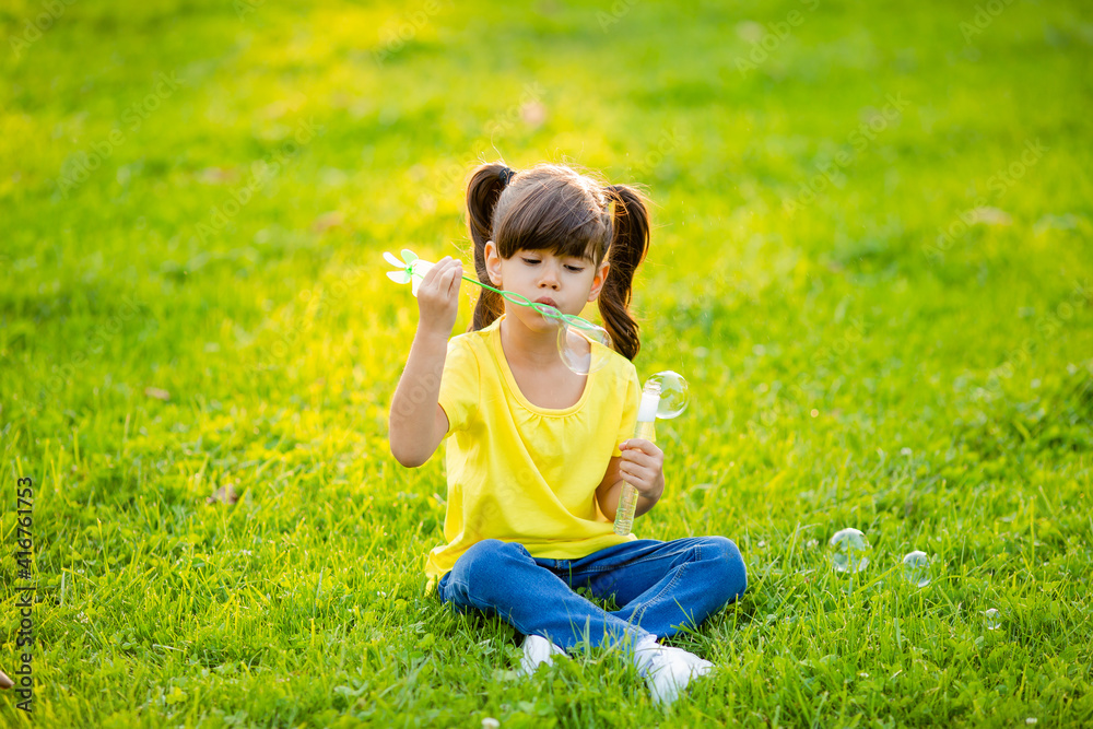 Cute little Indian girl summer on the lawn blowing soap bubbles Cute little Indian girl summer on the lawn blowing soap bubbles