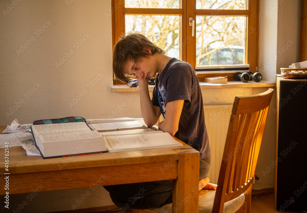 © Jesus - A teenaged boy in isolation studies at home during the corona virus pandemic © Jesus - A teenaged boy in isolation studies at home during the corona virus pandemic