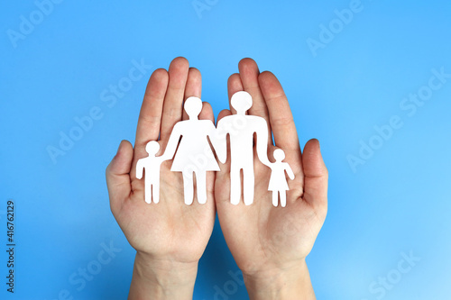 Paper family in hand on a blue background