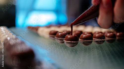 hand filling pralines with chocolate
