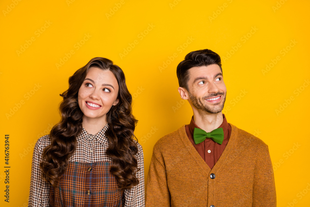 Photo of charming lady positive guy beaming smile look empty space imagine isolated on yellow color background Photo of charming lady positive guy beaming smile look empty space imagine isolated on yellow color background