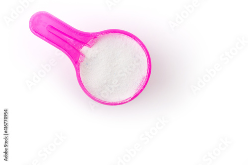 top view of washing powder in pink measuring spoon isolated on white background