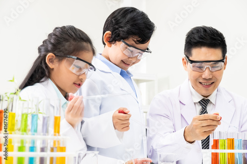 Selective focus at boy face. Young Asian boy and girl study science class using Microscope and chemical liquid to do the experiment inside laboratory. Education concept.