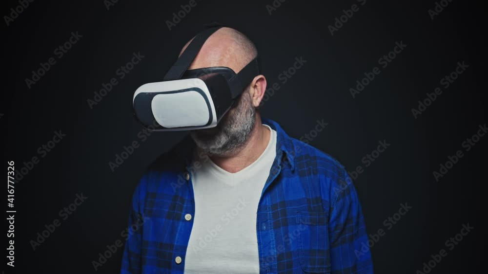 Mature man using VR headset for virtual reality in studio Mature man using VR headset for virtual reality in studio