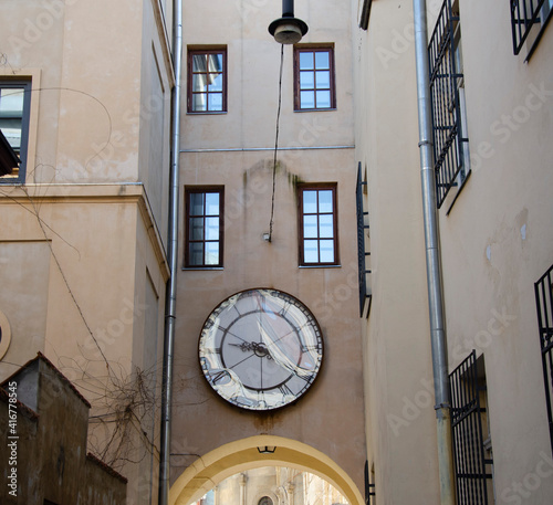 Cozy facade of the building with big wall clock. Lviv Old Town, Ukraine