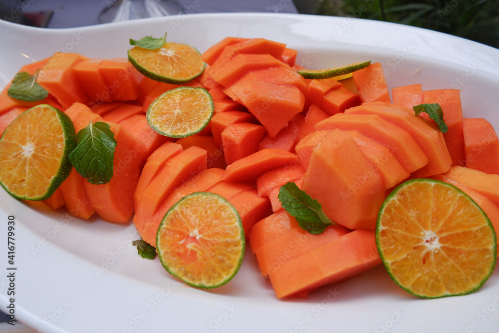 Fresh papaya slices and sweet orange on a plate. Healthy food Fresh papaya slices and sweet orange on a plate. Healthy food
