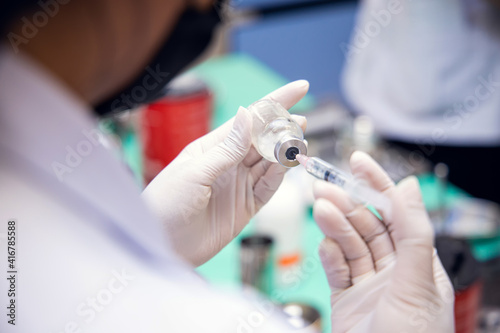 Close-up hand of doctor or nurse in laboratory holding a syringe and drawing liquid vaccines for vaccination to patient  children  person or older adults