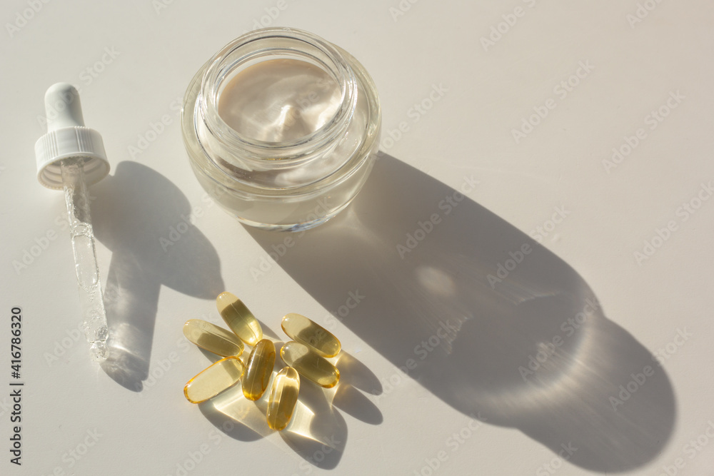 Skin care and supplements for clear and radiant skin. Closeup of beauty products and vitamin D capsules.