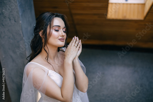 Wedding preparations. Beautiful young bride in white wedding dress indoors. © Ivan