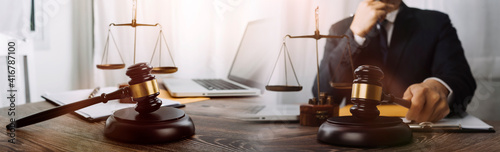 Business and lawyers discussing contract papers with brass scale on desk in office. Law, legal services, advice, justice and law concept picture with film grain effect