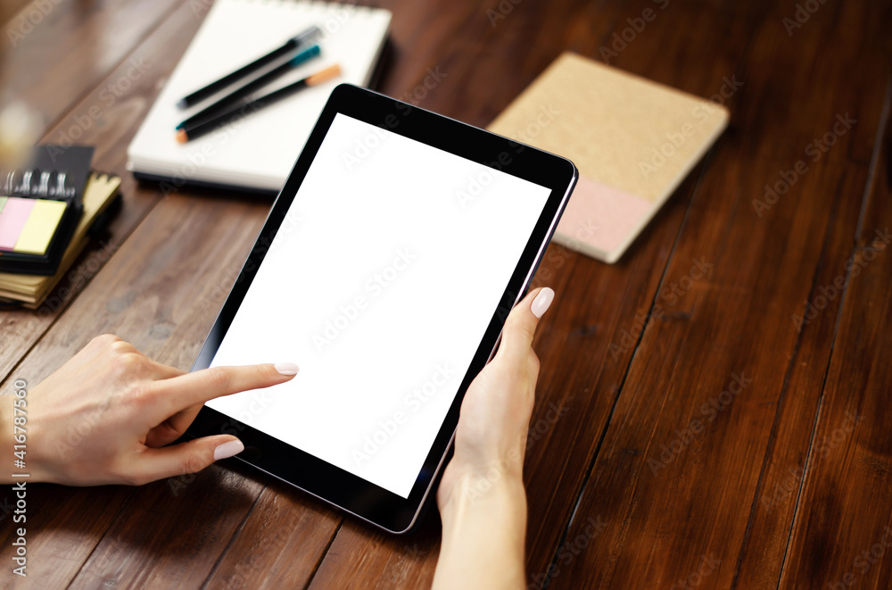 Mockup image of a woman using digital tablet with blank screen on wooden table. Close up photo of female hands holding device vertically Mockup image of a woman using digital tablet with blank screen on wooden table. Close up photo of female hands holding device vertically