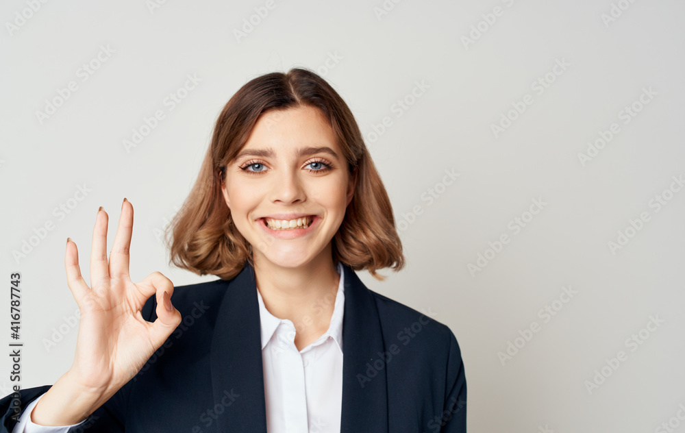 Energetic business woman in a suit gestures with her hands on a light background Copy Space Energetic business woman in a suit gestures with her hands on a light background Copy Space