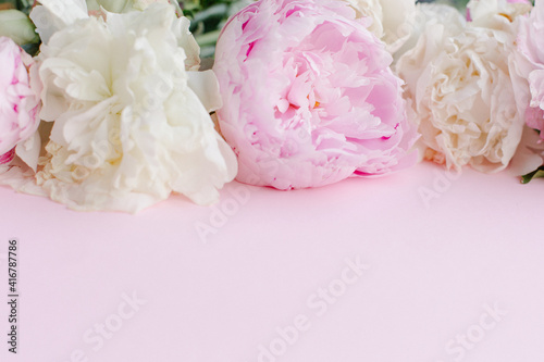 Delicate light beautiful pink background with a frame of peonies. Copy space for text. Floral border banner. Romance mothers day femininity womens day. Postcard texture spring summer peony