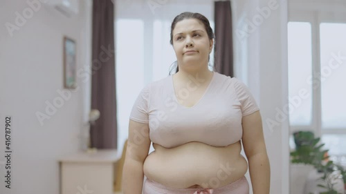 Depressed chubby woman suffering from excess abdominal fat, weight gain, diet photo