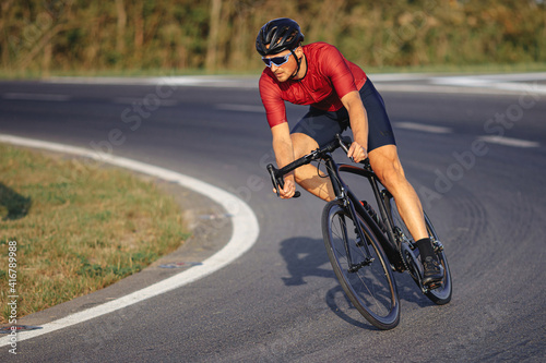 Sporty man in helmet and glasses riding bike