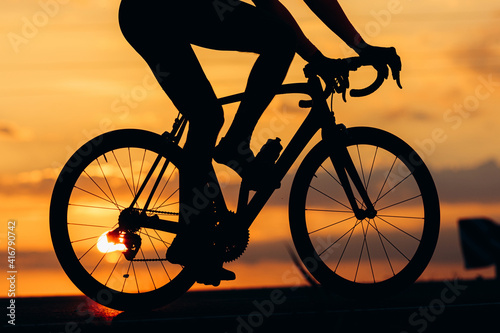 Silhouette of active man racing on road during sunset