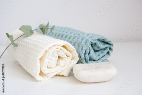 white and green towels, soap, and a branch of eucalyptus. skin care, home spa