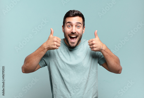 Obraz na plátně young handsome adult man smiling broadly looking happy, positive, confident and
