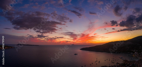Aerial panorama drone shot of sunset burning sky clouds on Komiza town over Vis Island in Croatia Summer