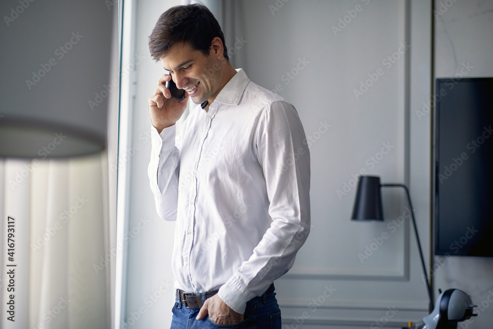 Young businessman starting a working day by the phone call from hotel room. Hotel, business, people Young businessman starting a working day by the phone call from hotel room. Hotel, business, people