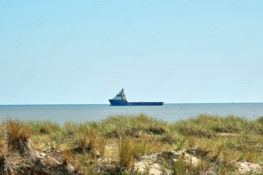 Boat leaves Great Yarmouth Outer Harbour. From South Beach, looking out to sea a service boat leaves the harbour. Boat leaves Great Yarmouth Outer Harbour. From South Beach, looking out to sea a service boat leaves the harbour.