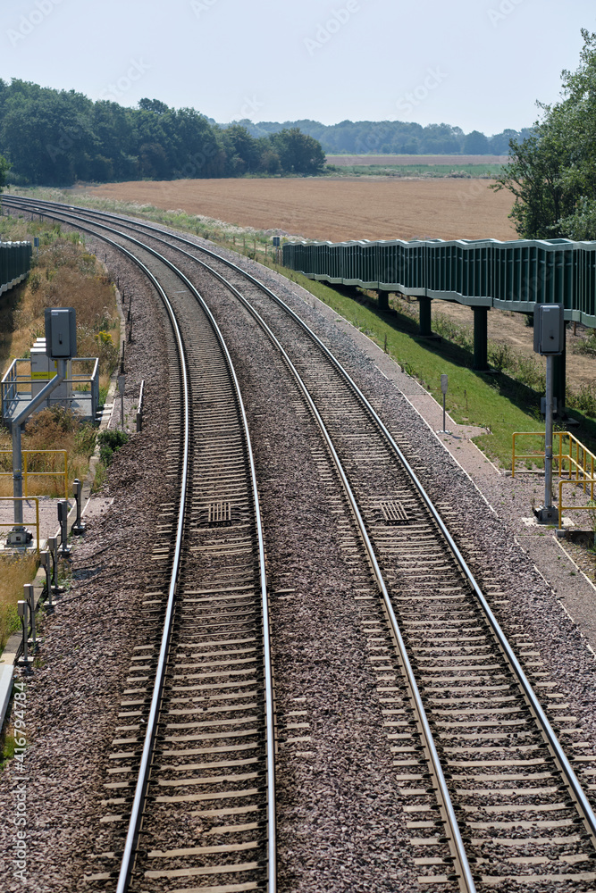 Close view of signals & curve in freight train track near Felixstowe.  Double curved rail line towards Felixstowe in Trimley. Close view showing signals & ramp for horses to use the bridge