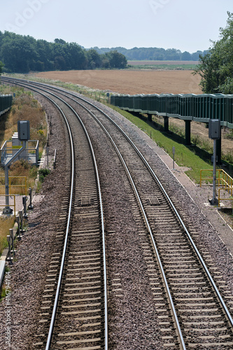 Close view of signals & curve in freight train track near Felixstowe.  Double curved rail line towards Felixstowe in Trimley. Close view showing signals & ramp for horses to use the bridge