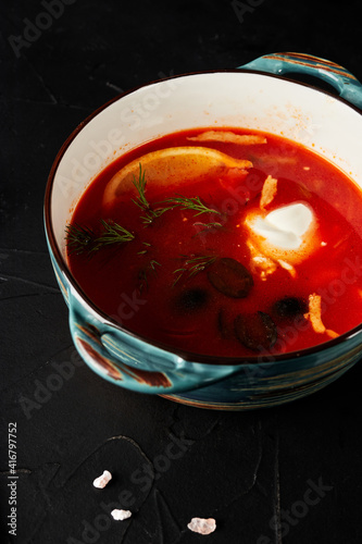 hodgepodge soup on black textured background with black spoon