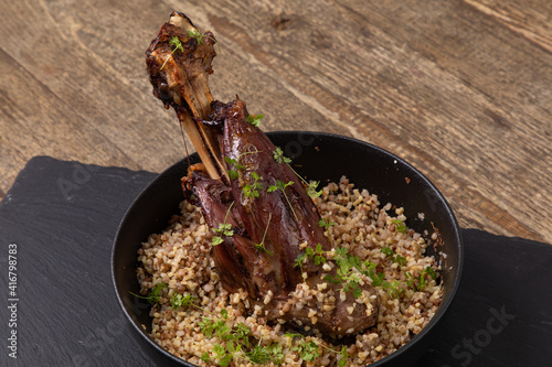 Cooked duck confit with buckwheat and micro greens in a bowl photo