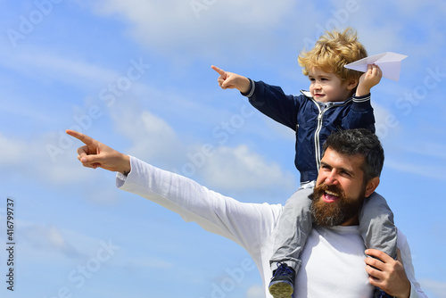 Father and son play with toy plane on the nature. Happy man family. Child playing with paper airplane. Generation. Parenting.