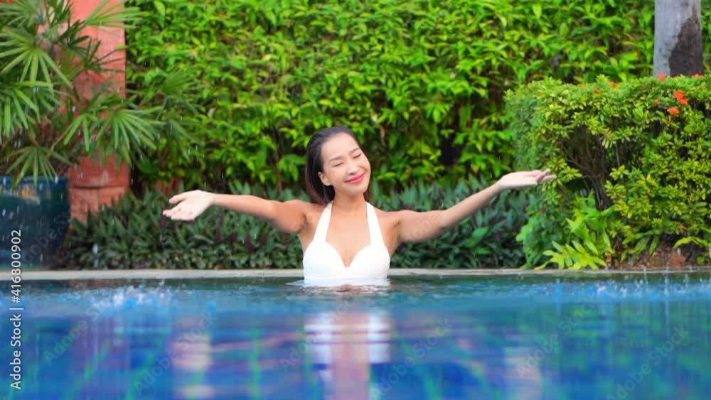 A playful young woman splashes pool water. A playful young woman splashes pool water.