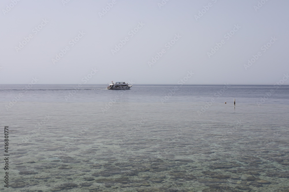 sail boat on the sea. Scenic seascape with swimming yacht near the coral reef in the Red Sea. Landscape of Egyptian coral coast and transparent clean water. 