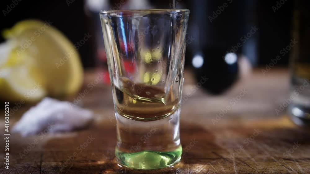Primer plano chupito de tequila reposado, sal y rodaja de limón fondo negro
