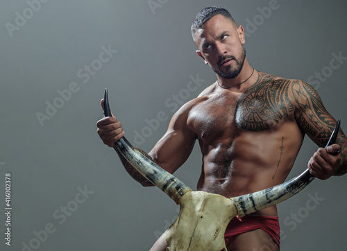 Handsome brutal man on gray background. Confident guy. Sexy look. Brutal handsome man with tattooed body. Men tattoo casual fashion. Muscular athletic sexy male with naked torso.