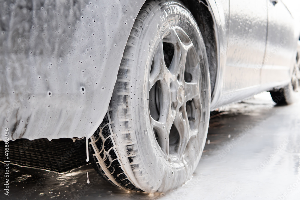 dirty car wheel in washing foam dirty car wheel in washing foam