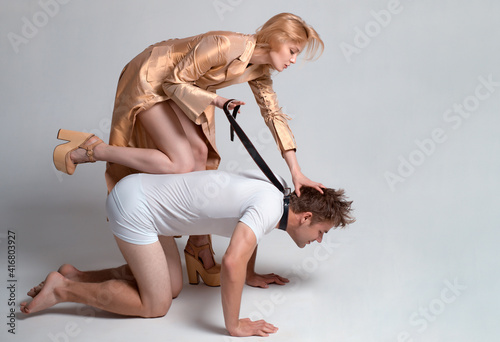 Mistress. Sexy lady on top of man. Bondage and Discipline. Dominate obey undress seduce a partner. Bdsm. Gender domination and role games. Woman and man playing dominant game, harassment.