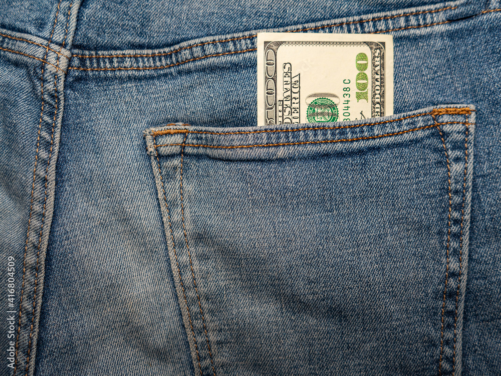 a hundred dollar bill sticks out of the back pocket of jeans a hundred dollar bill sticks out of the back pocket of jeans