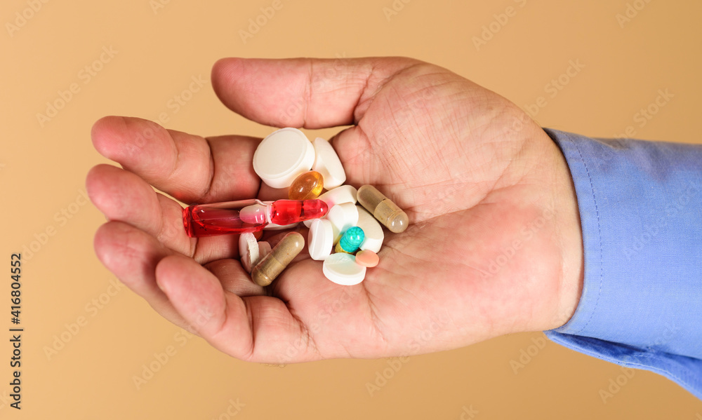 Man hands with pills. Medicine, treatments and healthcare. Tablets in hand of patient.