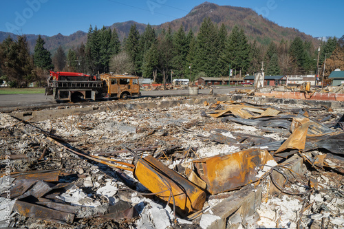 A home and fire engine in the city of Detroit Oregon, Willamette National Forest, were destroyed by the Beachie Creek Wildfire. Burned trees are on mountain in background.
