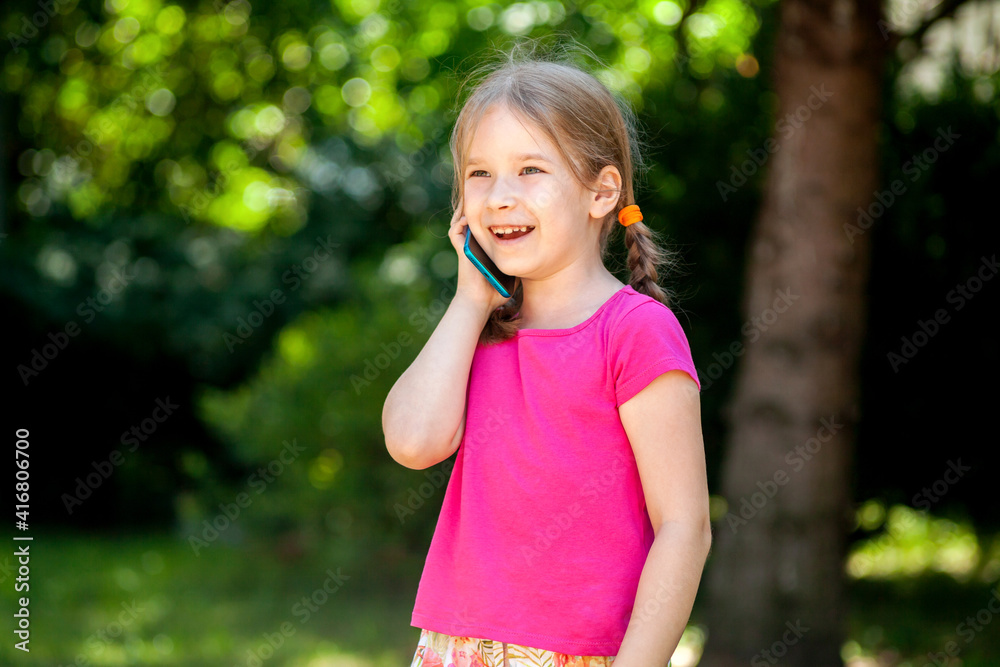 Happy cheerful little girl, child talking on phone laughing, young kid with a smartphone, phone call outdoors, portrait, copy space Telecommunication, mobile phone communication concept lifestyle shot Happy cheerful little girl, child talking on phone laughing, young kid with a smartphone, phone call outdoors, portrait, copy space Telecommunication, mobile phone communication concept lifestyle shot