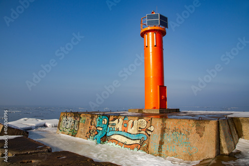 Navigation red lighthouse on Mangalsala pier in Baltic sea located at Riga sea port, Latvia, Europe photo