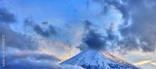 Fujiyama volcano - symbol of Japan in mysterious clouds in the light of the evening sun